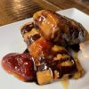 Decadent Raspberry Chimi from Atwater Street Tacos, combining raspberries and cream cheese in a fried tortilla, drizzled with chocolate syrup and caramel, garnished with fresh strawberries, presenting a fusion of classic Mexican flavors with a sweet twist.