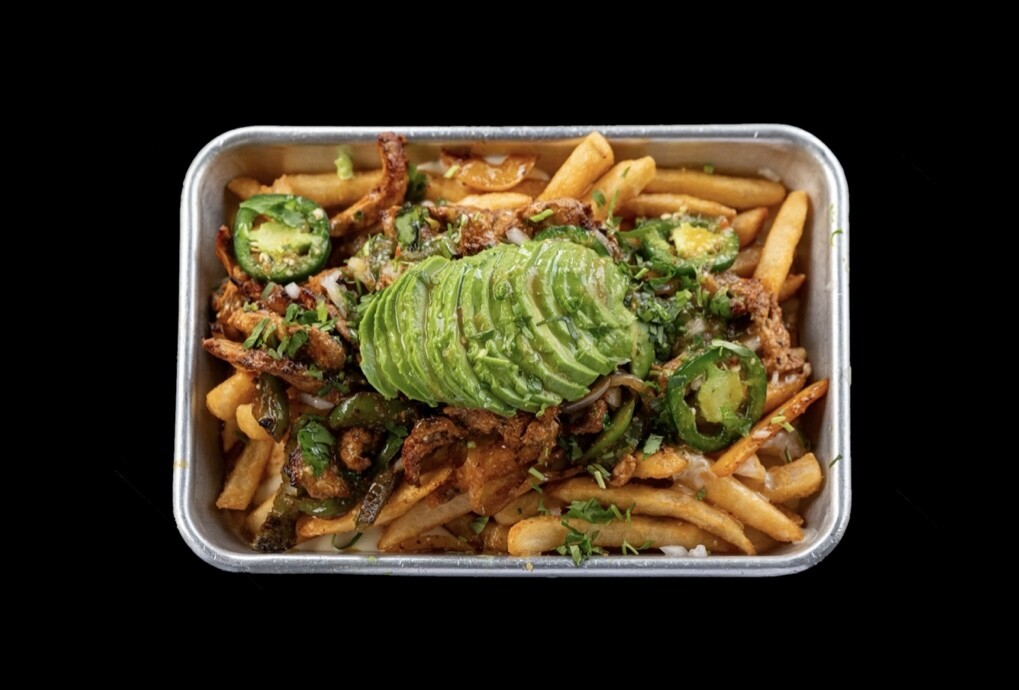 Image of Fajita Fries at Atwater Street Tacos, showcasing loaded golden fries topped with seasoned steak, chicken, or veggies, grilled onions, fajita peppers, creamy queso, fresh cilantro, jalapenos, avocado, and smoky salsa. A flavor-packed culinary adventure awaits!