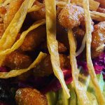 A colorful spread of authentic Mexican street tacos with fresh toppings, accompanied by vibrant, handcrafted cocktails on a rustic wooden table, capturing the essence of Atwater Street Tacos' dining experience.