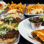 A vibrant platter of authentic Mexican street tacos from Atwater Street Tacos, showcasing various fillings and garnishes.